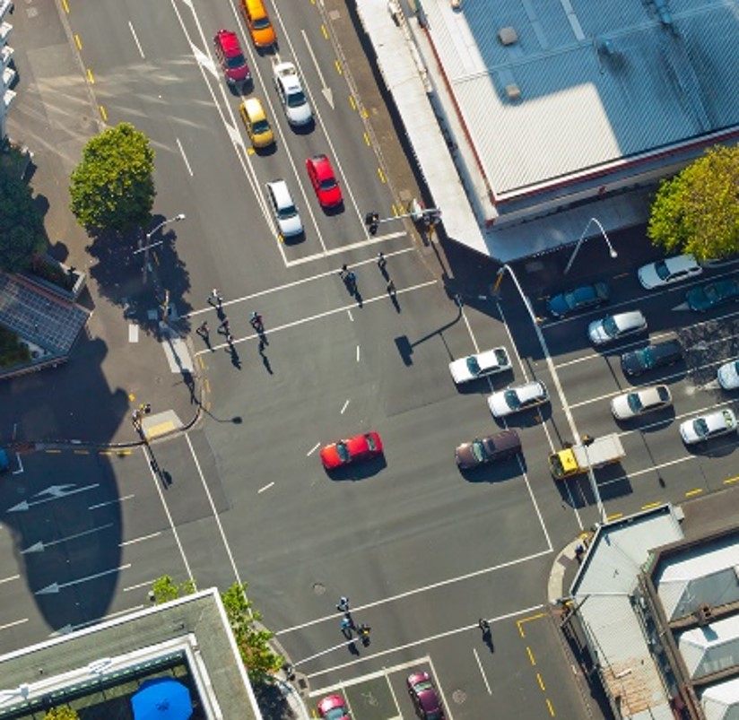An aerial view of vehicles at an urban intersection.