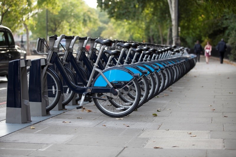A bikeshare docking station with several bikes lined up. 