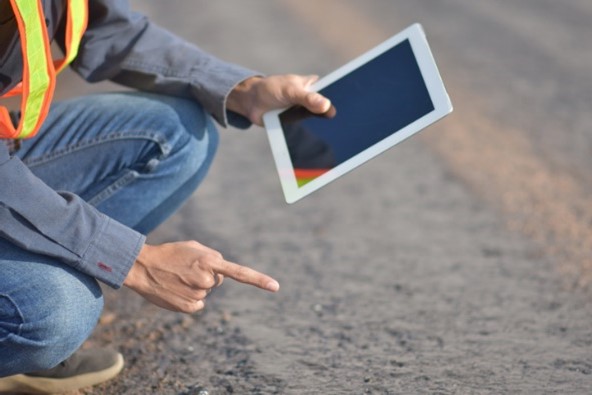 A person examining the ground using augmented reality on a tablet.  