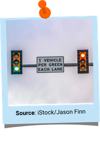 Picture of two traffic lights on a pole, one green and one red