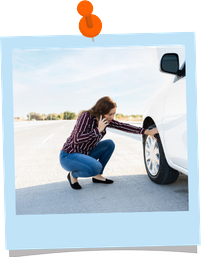 Person inspecting a hole in the tire on their car