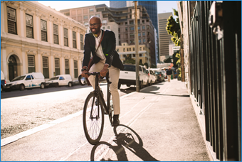 A man dressed in office attire riding a bike to work.