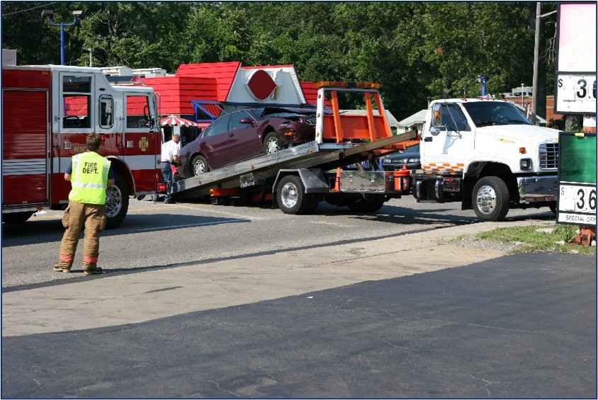 Figure 1 shows a car that has been involved in a crash being loaded onto a tow truck.
