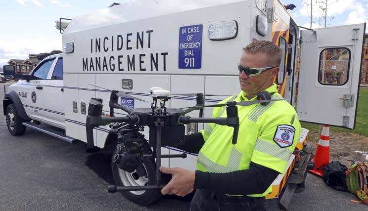 Image of Utah Department of Transportation employee holding drone for incident management operations. 