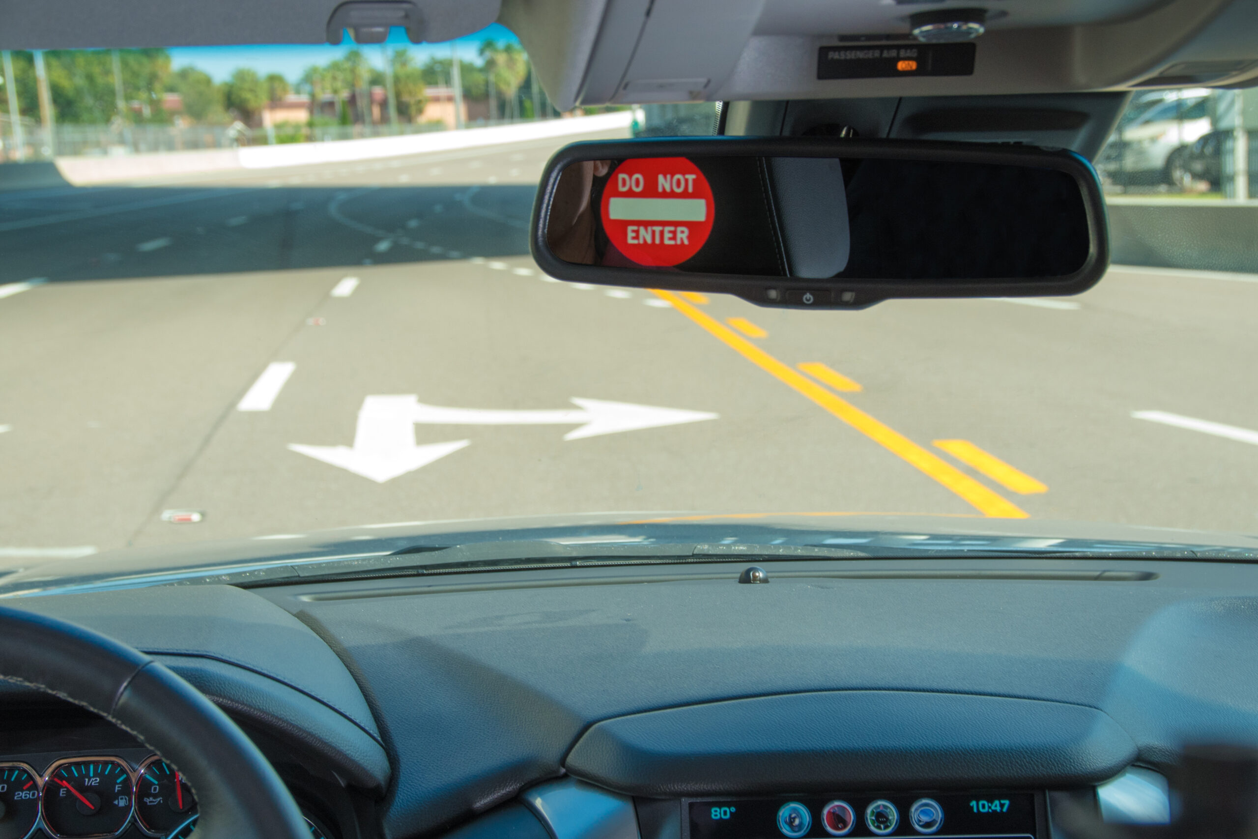 A red "Do Not Enter" visual alert is displayed in the rearview mirror as a driver drives in the wrong direction on the Express Lanes.