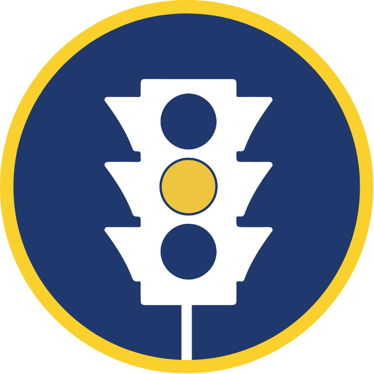 Icon of a traffic signal with a yellow border, featuring a white traffic light in the center on a blue background. The middle light of the signal is highlighted in yellow, while the top and bottom lights are blank.