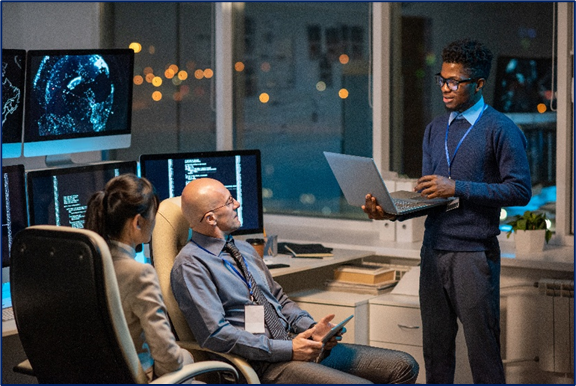Three people engaged in a meeting at work about cybersecurity