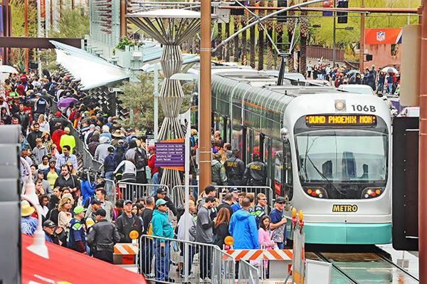 A light-rail station with people waiting for a train