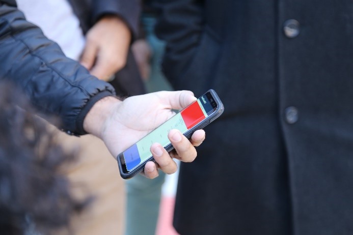A mobile device being held in a person's hand. 